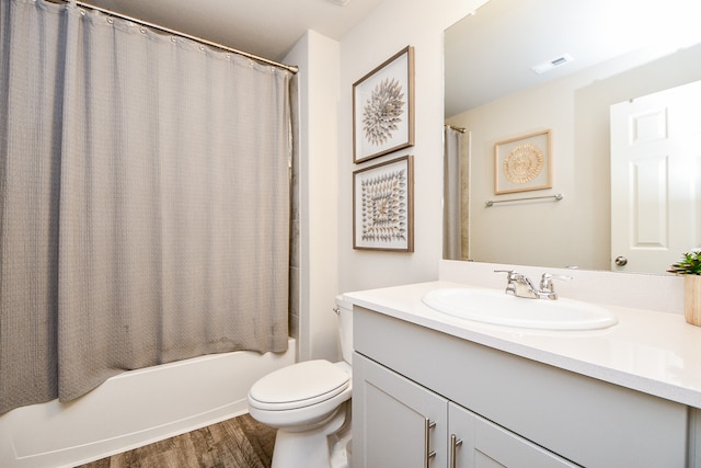 full bathroom featuring wood-type flooring, vanity, shower / tub combo, and toilet