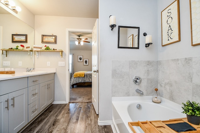 bathroom featuring vanity, hardwood / wood-style flooring, ceiling fan, and a bathing tub