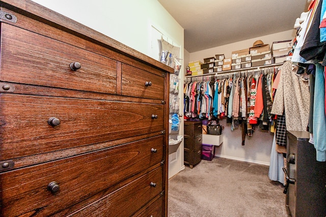 walk in closet featuring light colored carpet