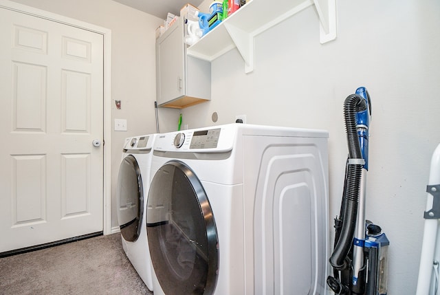 laundry room featuring cabinets, washer and clothes dryer, and light colored carpet