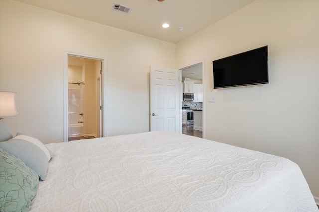 bedroom featuring connected bathroom and wood-type flooring