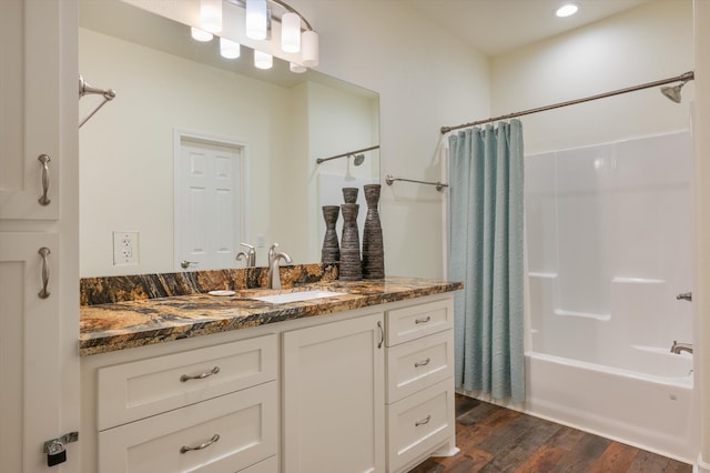 bathroom featuring vanity, shower / bathtub combination with curtain, and wood-type flooring