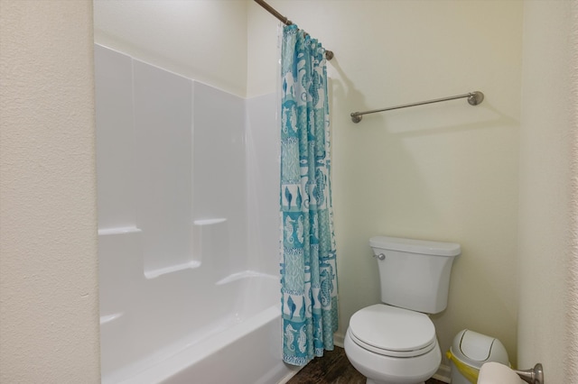 bathroom with hardwood / wood-style flooring, shower / bath combo, and toilet