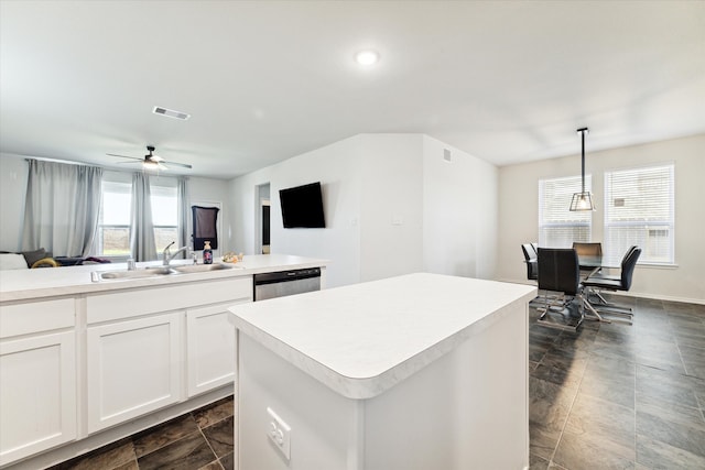 kitchen featuring pendant lighting, a center island, sink, ceiling fan, and white cabinetry