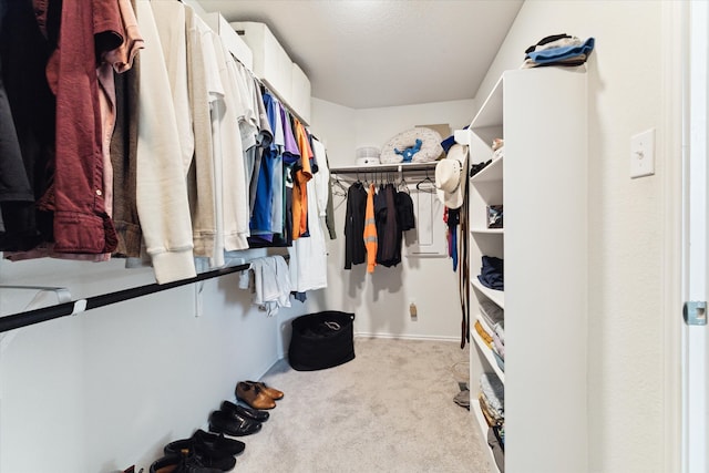 walk in closet featuring light colored carpet