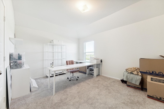 home office with light colored carpet and vaulted ceiling