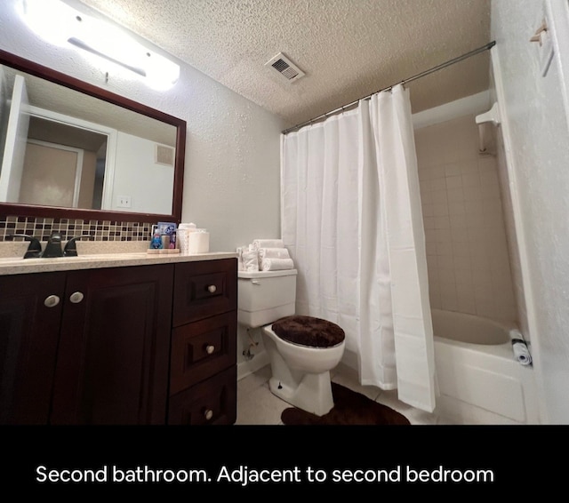 full bathroom with tasteful backsplash, vanity, shower / bath combo with shower curtain, tile patterned flooring, and toilet