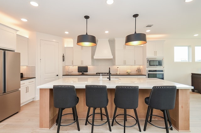 kitchen featuring white cabinets, a spacious island, and stainless steel appliances