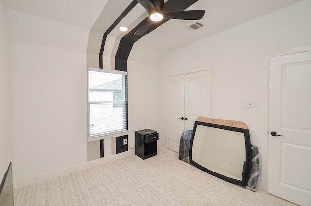 interior space featuring ceiling fan, light colored carpet, and vaulted ceiling