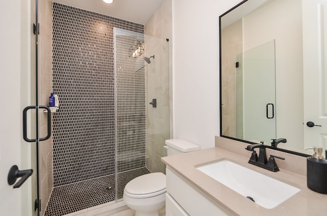 bathroom with vanity, a shower with shower door, and toilet