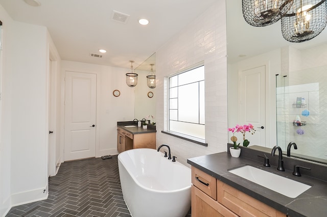 bathroom featuring vanity, plus walk in shower, and an inviting chandelier