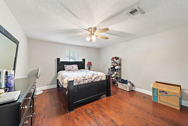 bedroom with a textured ceiling, dark hardwood / wood-style floors, and ceiling fan