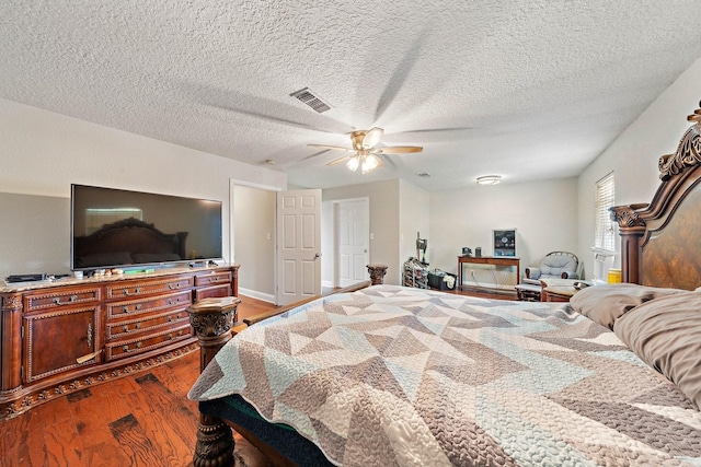 bedroom featuring ceiling fan, hardwood / wood-style floors, and a textured ceiling