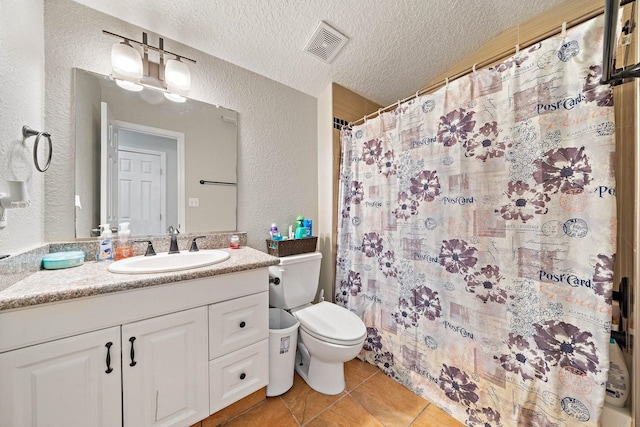 bathroom featuring a shower with shower curtain, vanity, a textured ceiling, tile patterned flooring, and toilet