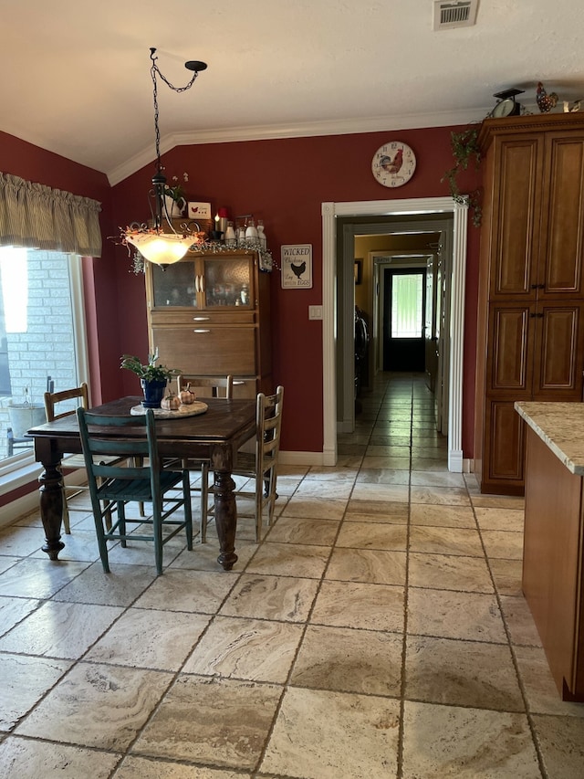 dining room with crown molding and lofted ceiling