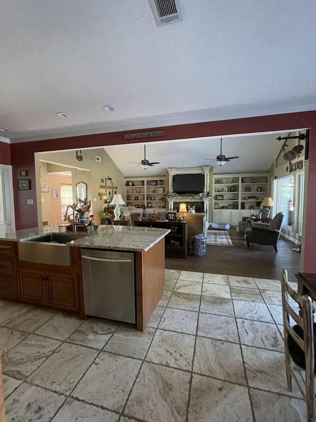 kitchen with dishwasher, sink, built in features, crown molding, and a center island with sink