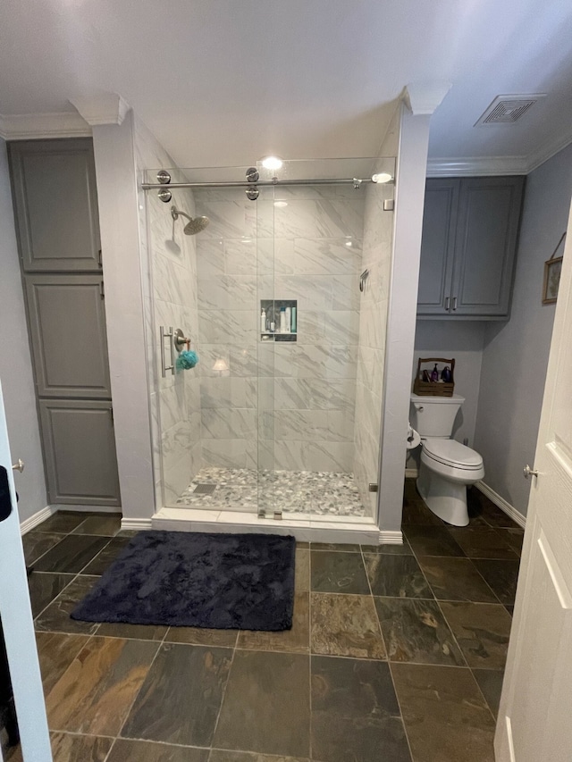 bathroom with toilet, ornamental molding, and a shower with door