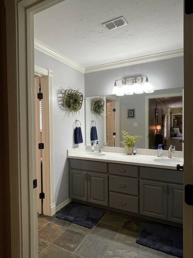 bathroom featuring vanity, a textured ceiling, and ornamental molding