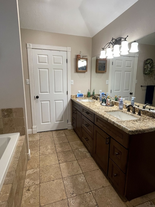 bathroom featuring vanity and tiled bath