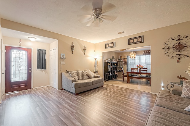 living room with ceiling fan, plenty of natural light, a textured ceiling, and hardwood / wood-style flooring