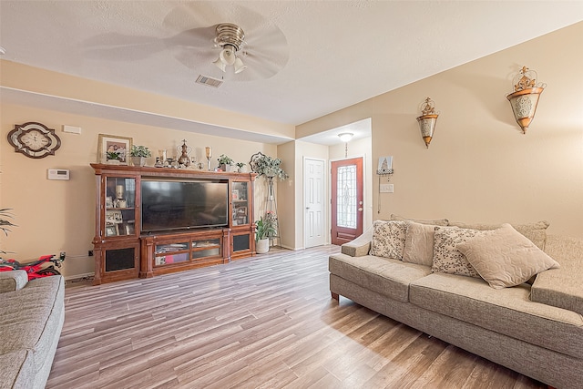 living room featuring ceiling fan and hardwood / wood-style flooring