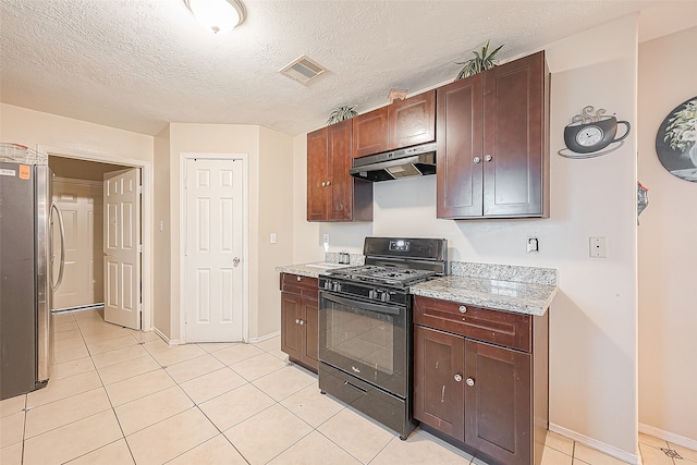 kitchen with stainless steel refrigerator, black range with gas cooktop, light tile patterned flooring, and a textured ceiling