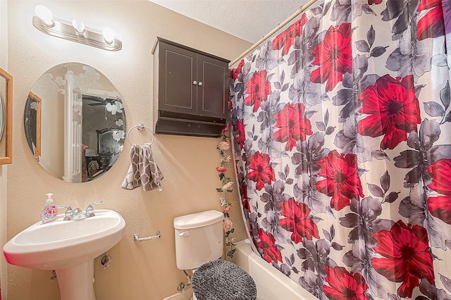 full bathroom featuring a textured ceiling, sink, shower / bath combo, and toilet