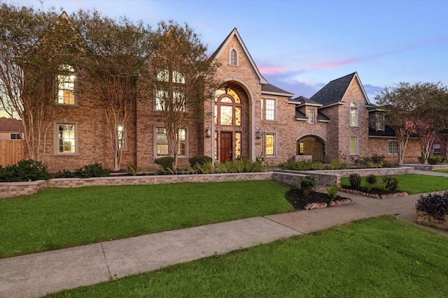 english style home featuring a lawn