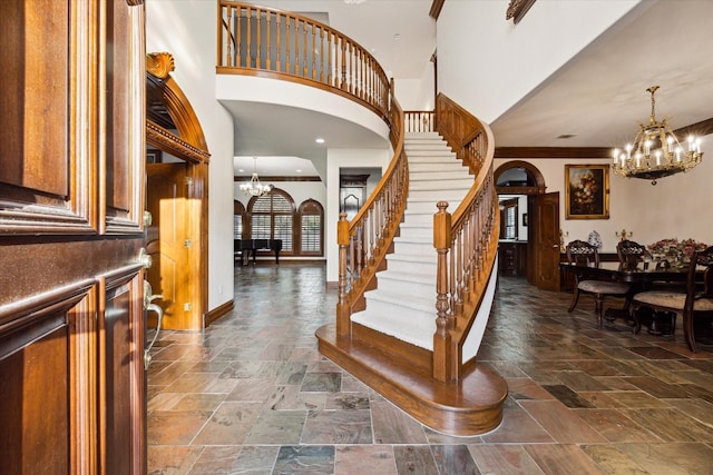 foyer entrance featuring a towering ceiling and crown molding