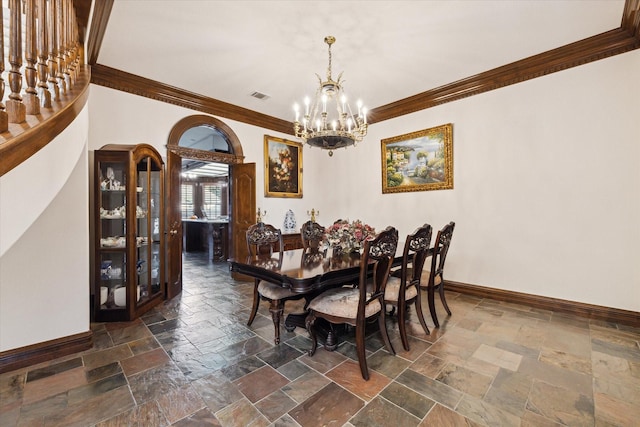 dining area with ornamental molding and a notable chandelier