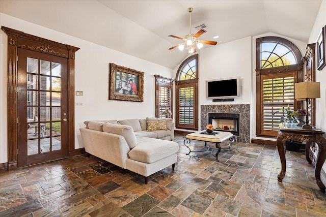 living room featuring ceiling fan, a healthy amount of sunlight, a fireplace, and high vaulted ceiling