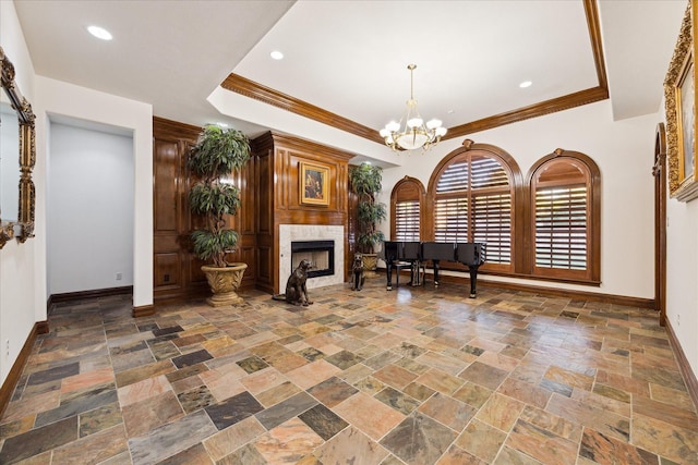 interior space featuring crown molding, a high end fireplace, and an inviting chandelier