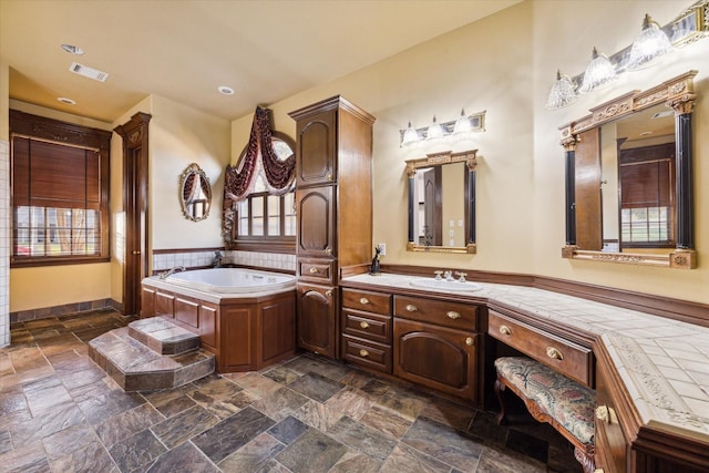 bathroom featuring vanity, a bathtub, and plenty of natural light