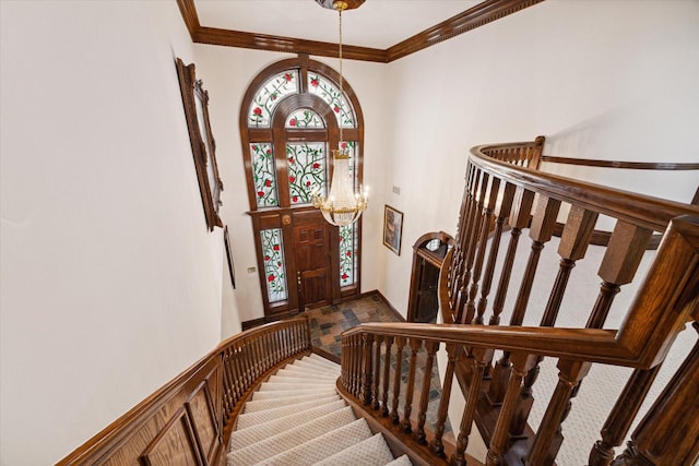 foyer entrance with an inviting chandelier and crown molding