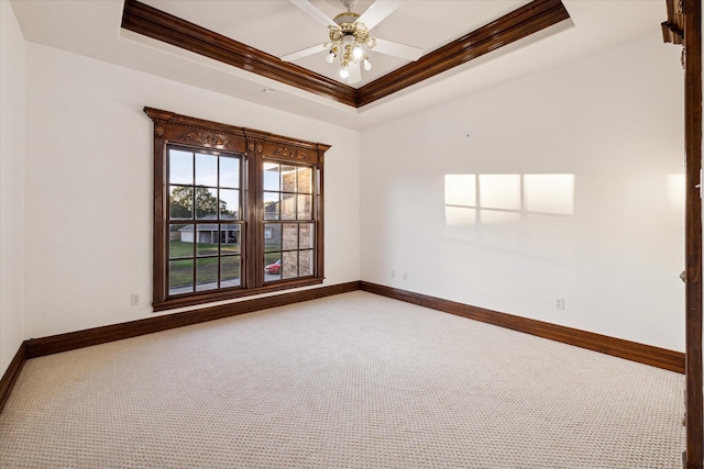 unfurnished room with carpet flooring, ceiling fan, ornamental molding, and a tray ceiling