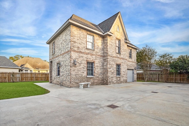 back of property featuring a garage and a yard