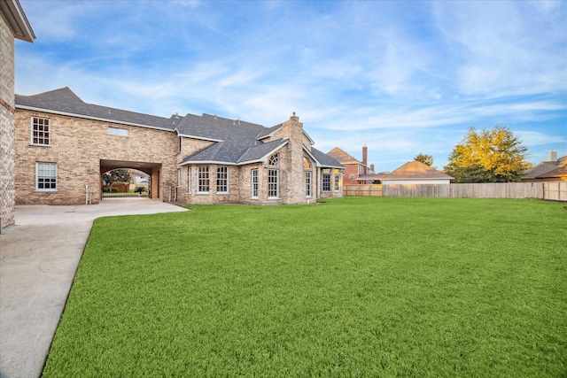 back of property with a lawn and a patio