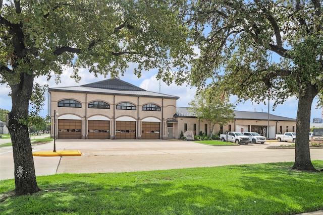 view of front of property with a garage and a front lawn