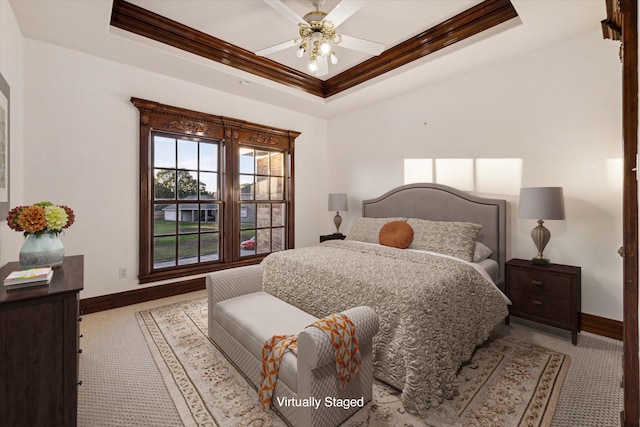 carpeted bedroom featuring a tray ceiling, ceiling fan, and ornamental molding