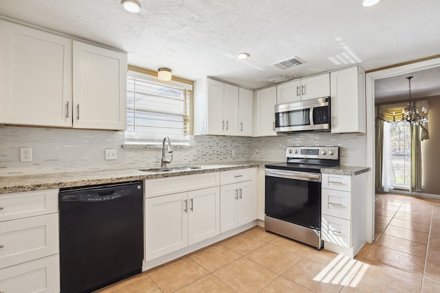 kitchen with pendant lighting, sink, stainless steel appliances, light stone counters, and white cabinets