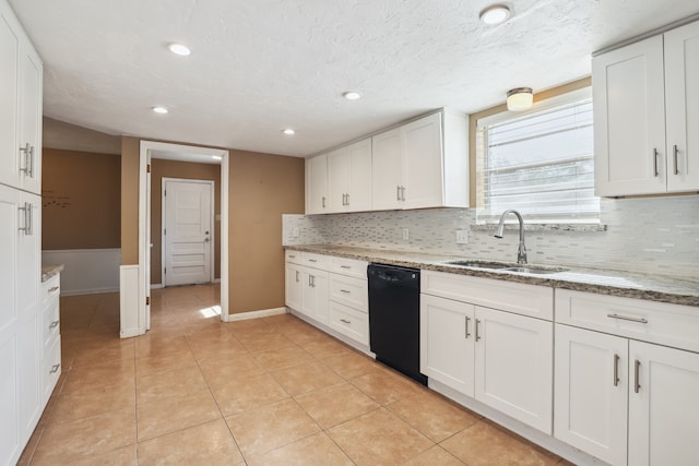 kitchen featuring light tile patterned flooring, black dishwasher, sink, white cabinets, and light stone counters