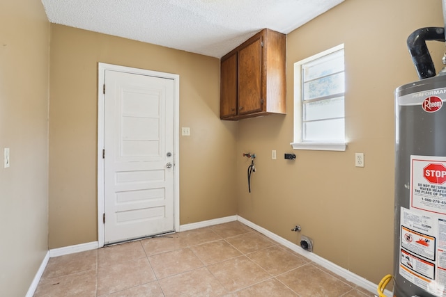 washroom featuring gas water heater, cabinets, a textured ceiling, light tile patterned floors, and hookup for a washing machine