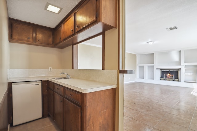 kitchen with built in shelves, crown molding, light tile patterned floors, dishwashing machine, and kitchen peninsula