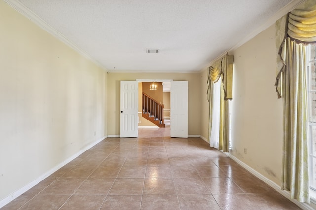 unfurnished room with crown molding, a textured ceiling, and light tile patterned floors