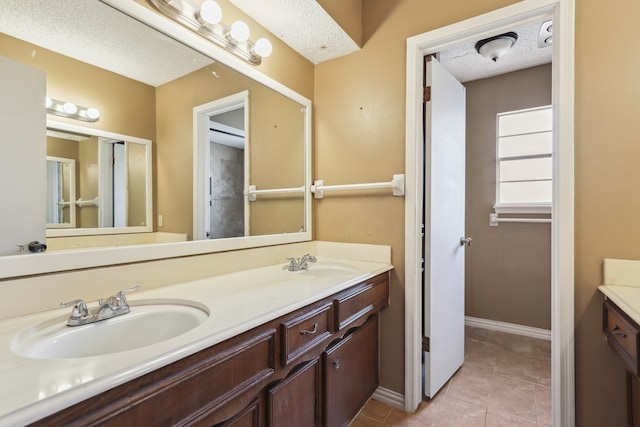 bathroom with vanity, tile patterned flooring, and a textured ceiling