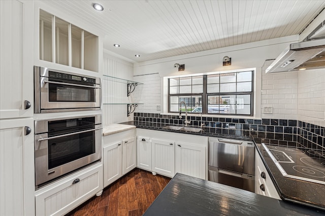 kitchen with white cabinets, sink, decorative backsplash, dark hardwood / wood-style flooring, and stainless steel appliances