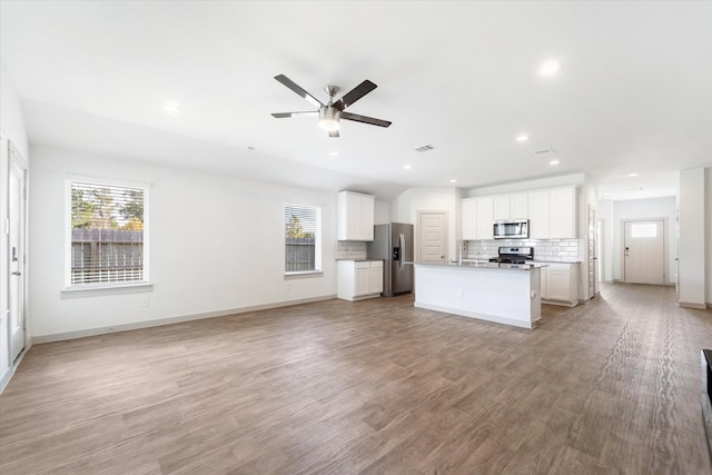 unfurnished living room with light hardwood / wood-style flooring and ceiling fan