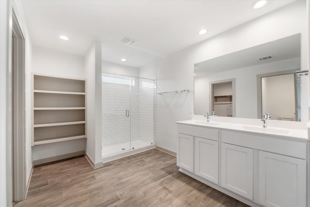 bathroom with hardwood / wood-style flooring, vanity, and a shower with shower door