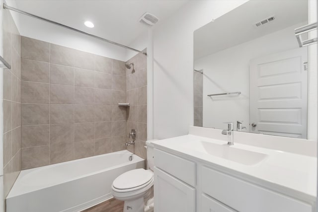 full bathroom featuring toilet, vanity, wood-type flooring, and tiled shower / bath