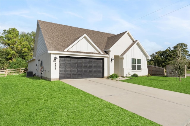 view of front of property featuring central AC unit, a garage, and a front lawn